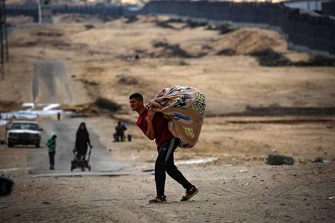 13일(현지시각) 팔레스타인 가자지구 남부 라파흐에 대한 이스라엘 공습이 계속되는 가운데 팔레스타인 주민이 짐을 챙겨 이동하고 있다. AFP 연합뉴스