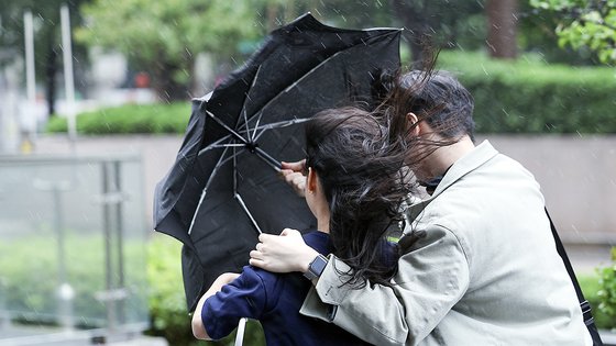 전국에 강풍을 동반한 비가 온 11일 오후 서울 종로구 도심을 지나는 한 시민들이 강한 바람에 위태로운 모양의 우산에 의지한 채 발걸음을 재촉하고 있다. 뉴스1