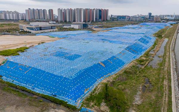 부산 강서구 명지국제신도시 국회부산도서관 앞 공터에 중금속 오염토가 방수포에 덮혀 방치돼 있다. 국제신문 DB