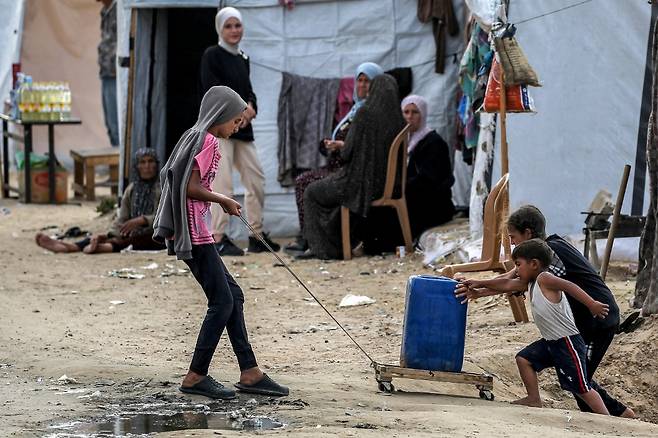 지난달 30일(현지시간) 가자지구 라파에서 팔레스타인 아이들이 비탈길에서 플라스틱 통을 옮기고 있다../AFPBBNews=뉴스1