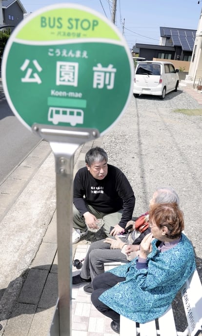 지난달 1일 일본 미에현 메이와초(町)에 세워진 '가짜 버스 정류장'에서 노인 간병 사업을 하는 나카무라 히데토(52)씨가 벤치에 앉은 노인 두 명과 대화하고 있다./요미우리 온라인