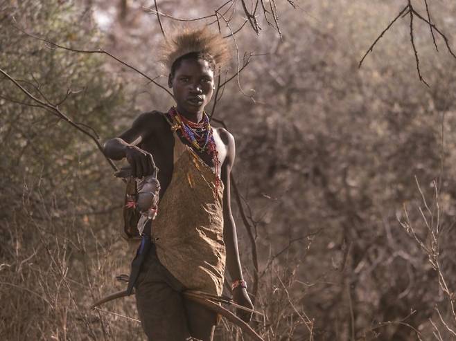 탄자니아의 하자베족 여성이 사냥으로 잡은 새를 들어보이고 있다. 최근 연구를 통해 여성 사냥꾼에 관한 인식이 점점 보편화되고 있다.A_Peach(W) 제공