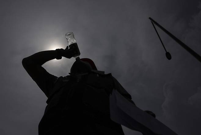 무더위가 이어지던 지난해 8월2일 서울 용산 대통령 집무실 앞에서 열린 ‘건설노조 폭염 기자회견’에서 한 참석자가 물을 마시고 있다. 연합뉴스