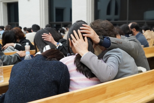지난해 3월 경기도 성남의 독수리기독학교에서 열린 조부모초청예배 현장. 학부모와 조부모, 자녀가 서로의 머리에 손을 대고 기도하고 있다. 독수리기독학교 제공