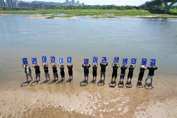 전국의 녹색연합 활동가들이 세종보 인근 금강에 들어가 손팻말을 들어보이고 있다. 대전충남녹색연합 제공