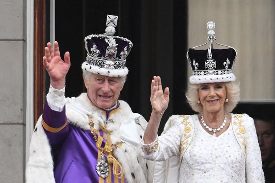 지난해 5월 대관식에서 왕관을 쓴 채 버킹엄 궁 발코니에서 손을 흔드는 찰스 3세와 커밀라 왕비. AFP=연합뉴스