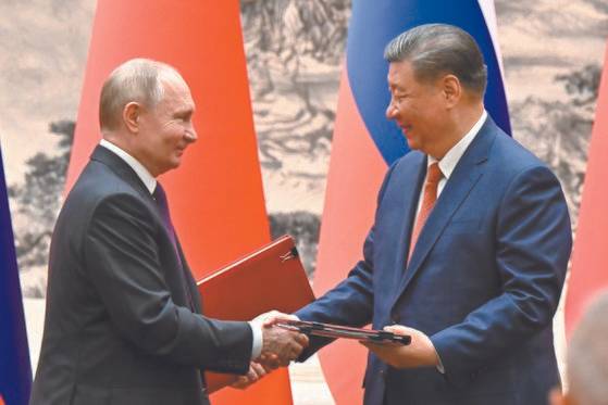 블라디미르 푸틴(왼쪽) 러시아 대통령과 시진핑 중국 국가 주석이 16일 중국 베이징에서 회담 중 서명한 문서를 교환하면서 악수하고 있다. 타스=연합뉴스