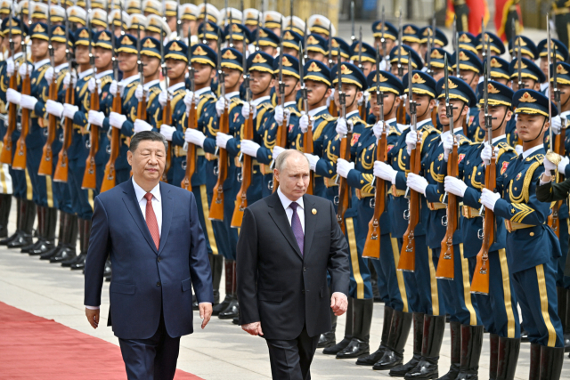 중국을 국빈 방문한 블라디미르 푸틴(오른쪽) 러시아 대통령이 16일 베이징 톈안먼 광장이 보이는 인민대회당 앞에서 열린 공식 환영 행사에서 시진핑 중국 국가주석과 나란히 걸으며 의장대를 사열하고 있다. 로이터연합뉴스