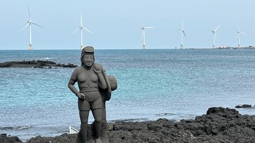 해녀 석상을 뒤로 한 제주 탐라해상풍력발전단지  [촬영 차대운]