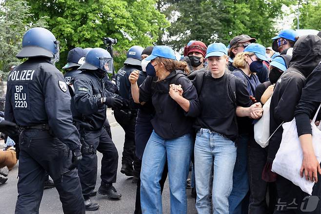 독일이 환경 시위대가 10일(현지시간) 베를린 인근에 있는 테슬라 기가팩토리를 습격하는 것을 경찰이 막고 있다. 이들은 테슬라가 공장 건설을 위해 주변 숲을 남벌했다는 이유로 시위를 벌였다. ⓒ 로이터=뉴스1 ⓒ News1 박형기 기자