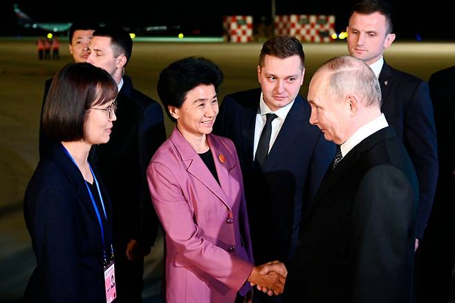 중국을 국빈 방문 중인 블라디미르 푸틴(오른쪽) 러시아 대통령이 17일 새벽 하얼빈 공항에 도착해 관계자들의 환영을 받고 있다./AP 연합뉴스