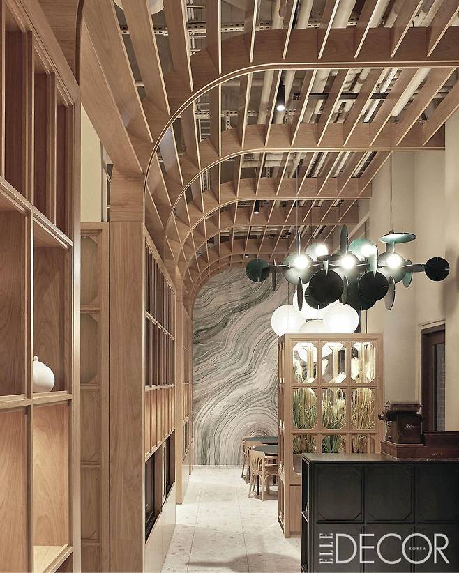 수원 광교 앨리웨이에 자리 잡은 그로서런트 키친 ‘아오로(Aoro)’. 천장 구조와 조명, 벽 패턴이 중첩되면서 깊이 있는 공간을 만들어낸다.