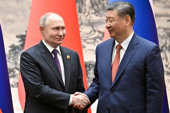 블라디미르 푸틴 러시아 대통령(왼쪽)이 16일 중국 베이징에서 열린 정상회담에서 시진핑 중국 국가주석과 악수하고 있다. 로이터연합뉴스