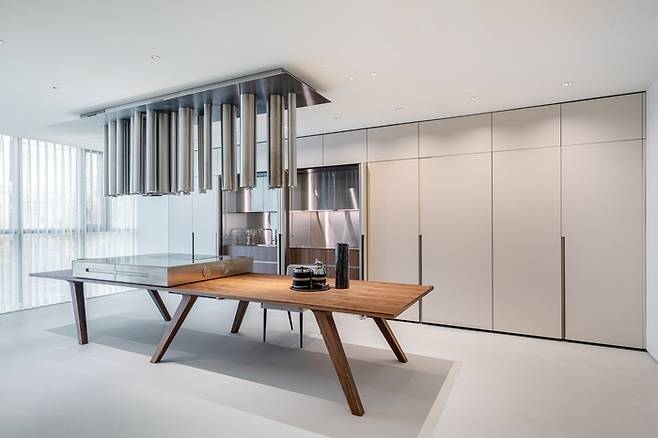 엘마(Elmar)의 아일랜드. 상부에 설치된 파이프는 주방 후드 역할과 동시에 스피커, 조명 기능까지 갖추고 있다. <넥시스 디자인 그룹>