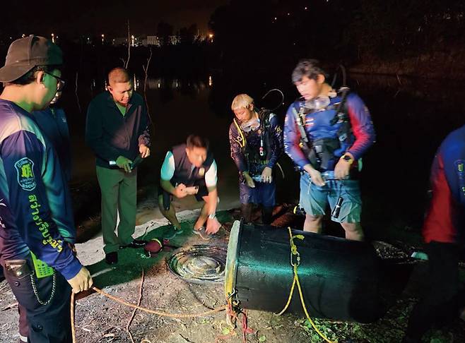 태국 경찰이 5월11일 촌부리주 파타야에서 시신이 담긴 검은 플라스틱 드럼통을 조사하고 있다. ⓒAP 연합