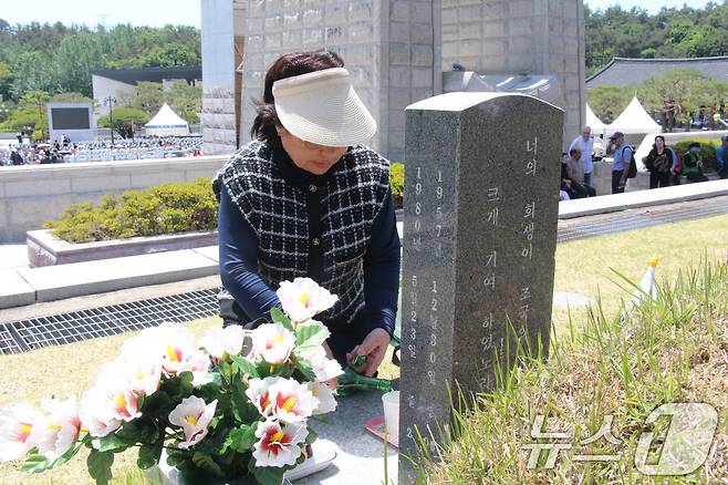 고 안병섭 씨의 동생 안복희 씨가 18일 기념식이 끝난 뒤 동생의 묘지를 지키고 있다. 2024.5.18/뉴스1 ⓒ News1 박지현 기자