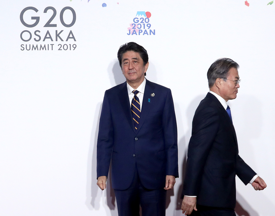 문재인 전 대통령(오른쪽)이 2019년 6월 28일 일본 오사카에서 열린 G20 정상회의 공식 환영식에서 의장국인 아베 신조 당시 총리와 악수한 뒤 자리로 이동하고 있다. [중앙포토]