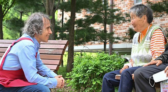 Father Kim Ha-jong talks with a woman near Anna’s House in Seongnam, Gyeonggi Province, April 30. (Lim Se-jun/The Korea Herald)