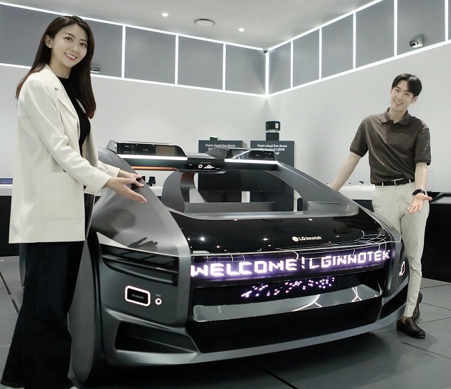 LG이노텍 직원들이 미래차 목업(Mock-up)에 장착된 차량 조명 모듈 '넥슬라이드'를 선보이고 있다./사진=LG이노텍 제공