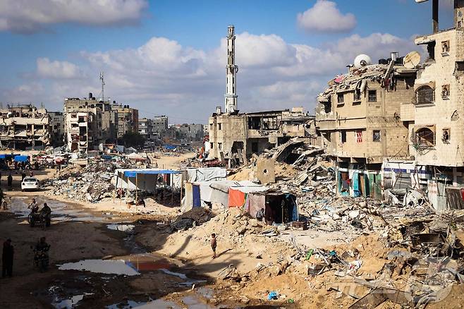 16일 이스라엘군 공격으로 폐허가 된 가자지구 남쪽 도시 칸 유니스의 건물 잔해사이로 팔레스타인 피난민들의 널빤지 판잣집들이 들어서 있다. 2024.05.16 ⓒ AFP=뉴스1 ⓒ News1 김성식기자