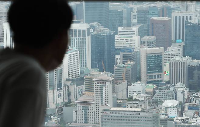 한 남성이 서울 남산타워에서 주요 기업 빌딩이 밀집한 도심을 바라보고 있다. / 뉴스1