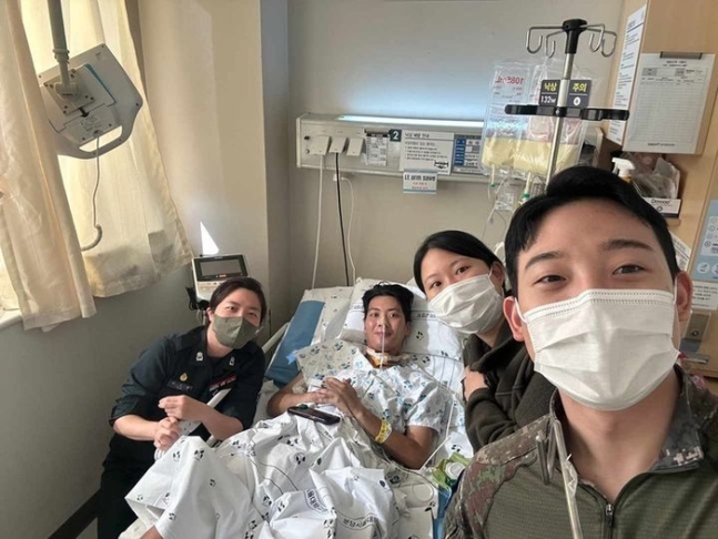 작성자 A씨가 공개한 사진. 사연의 주인공인 최 중사가 병원 침실에 누워있고, 동료들이 그 주변을 둘러싸고 서 있다./사진=페이스북 페이지 ‘육군훈련소 대신 전해드립니다’ 캡처