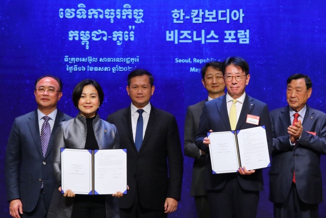 KB Kookmin Bank CEO Lee Jae-keun (front right) and National Bank of Cambodia Governor Chea Serey (front left) pose for a photo during a ceremony at the Korea Chamber of Commerce and Industry in central Seoul, Thursday. (KB Kookmin Bank)