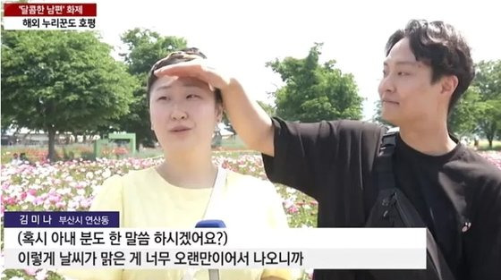 '인간 양산'을 자처하며 아내의 이마에 손을 갖다 대 햇빛을 막아주는 사랑꾼 남편. 사진 YTN 캡처