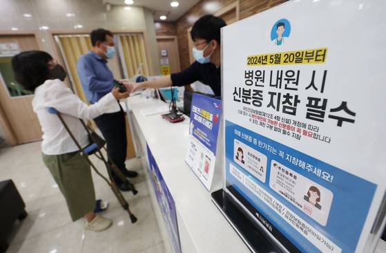 A patient presents her mobile ID card at a hospital in Dongjak District, southern Seoul, to access medical treatment under the national health insurance system. Beginning Monday, patients visiting medical facilities are required to present an ID card to receive health insurance coverage. [NEWS1]