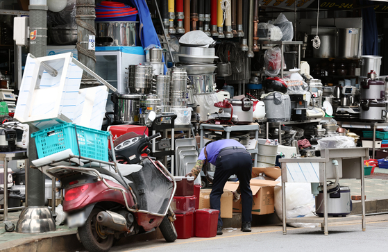 A seller of used kitchen products moves packages at a store in Hwanghak-dong, central Seoul, on Monday. [YONHAP]