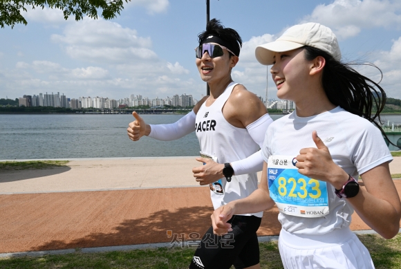 지난 18일 ‘2024 서울신문 하프마라톤대회’에 참가한 기상캐스터 오요안나(오른쪽·28)씨가 다른 참가자와 함께 난지 한강공원 코스를 달리고 있다. 홍윤기 기자