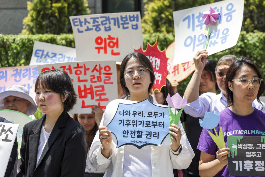 21일 서울 종로구 헌법재판소 앞에서 열린 기후 헌법소원 마지막 공개변론 공동 기자회견에서 참가자들이 피켓을 들고 있다. (사진=뉴시스)