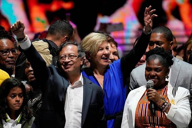구스타보 페트로 콜롬비아 대통령이 2022년 6월19일 밤(현지시각) 수도 보고타에서 대선 결선 승리 뒤 부인 베로니카 알코세르(가운데), 프란시아 마르케스 부통령 당선자(오른쪽)와 함께 손을 흔들고 있다. AP 연합뉴스