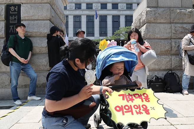 한국 정부의 기후변화 대응이 헌법에 합치하는지를 묻는 기후소송 두번째 공개 변론이 열린 21일 오후 서울 종로구 헌법재판소 앞에서 기후소송 원고 단체의 기자회견이 열려 한 어린이가 유아차 앞에 손팻말을 붙인 채 참석하고 있다. 백소아 기자 thanks@hani.co.kr