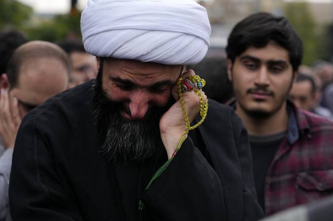 20일(현지시간) 이란 테헤란 시내 발리-에-아스르 광장에서 한 성직자가 에브라힘 라이시 이란 대통령의 애도식에서 눈물을 흘리고 있다. [AP]