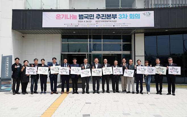 [태안=뉴시스] 지난달 26일 태안 유류피해극복기념관에서 열린 제3차 온기나눔 범국민 추진본부 회의에 참석한 인사들이 '온기나눔' 손 팻말을 들고 기념 촬영을 하고 있다. (사진=태안군 제공) 2024.05.21.  *재판매 및 DB 금지