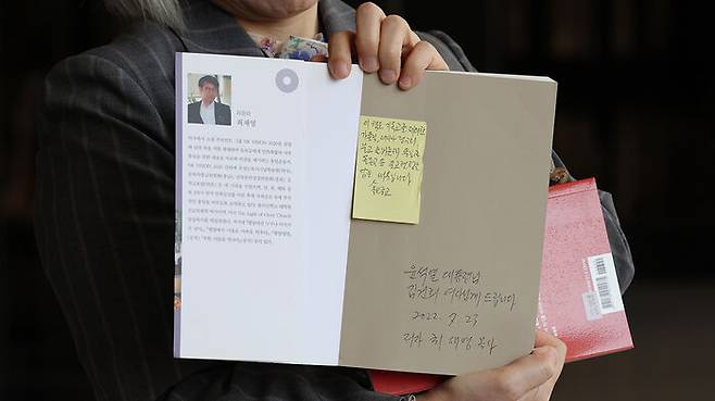 '명품 가방 수수 의혹' 관련 책 들어보이는 권성희 변호사