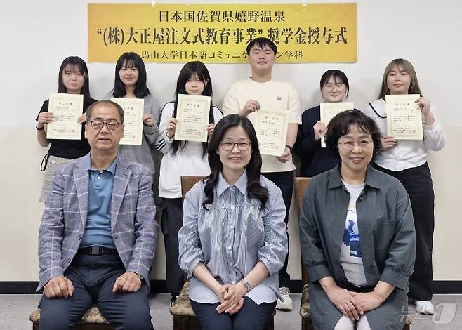 마산대 학생들이 일본기업 다이쇼야의 장학금을 전달받은 뒤 교직원들과 기념사진을 촬영하고 있다.(마산대 제공)
