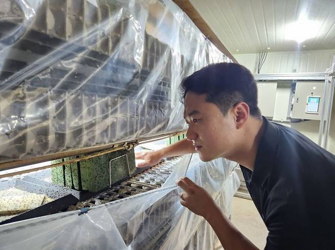이봉학 반달소프트 대표가 식용 곤충 스마트팜에서 곤충을 살펴보고 있다.