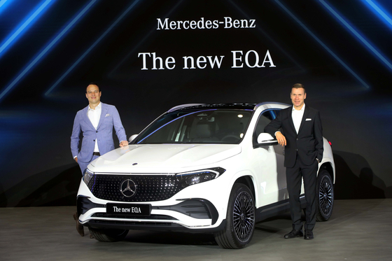Mercedes-Benz Korea CEO Mathias Vaitl, right, and Kilian Thelen, vice president of product, marketing, and digital business pose with the latest EQA after a press event in central Seoul on Tuesday. [MERCEDES-BENZ KOREA]