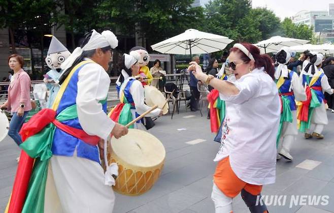 우리의 전통 북장단에 외국인 관광객이 길놀이패와 함께 춤을 추고 있다.