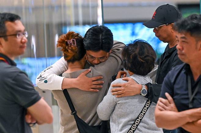 심한 난기류를 겪은 싱가포르항공 SQ321편에 탄 한 승객이 22일(현지시간) 싱가포르 창이공항에 도착해 가족들을 만나 껴안고 있다./AFPBBNews=뉴스1