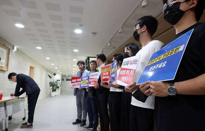 의대 증원을 담은 학칙 개정을 위한 전북대학교 교수평의회가 열린 22일, 의대 교수 및 학생들이 대학 본부 현관 앞에서 손팻말을 들고 의대증원 반대를 촉구하고 있다.(사진=연합뉴스)