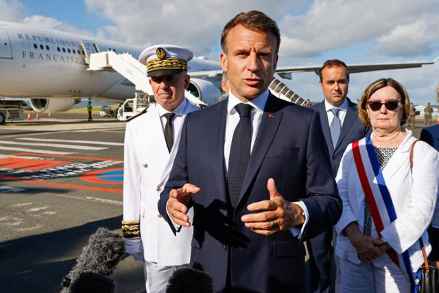 에마뉘엘 마크롱(왼쪽 두 번째) 프랑스 대통령이 23일 남태평양 프랑스령 누벨칼레도니 수도 누메아 인근 라톤투타 국제공항에 도착해 취재진 앞에서 이야기하고 있다. 누메아=AP 연합뉴스