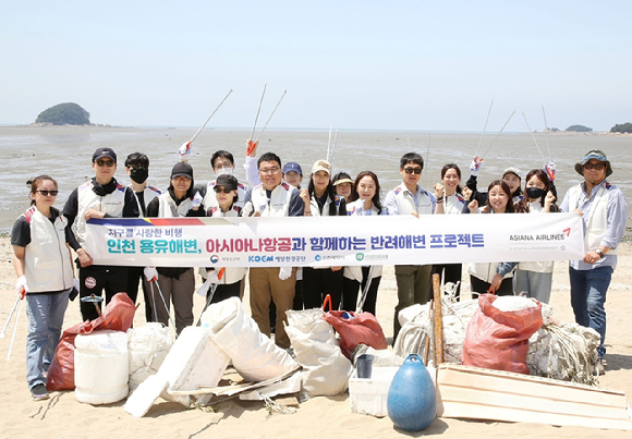 아시아나항공 직원들이 23일 인천 용유해변에서 정화 활동을 마친 후 기념 촬영을 하고 있다. [사진=아시아나항공]