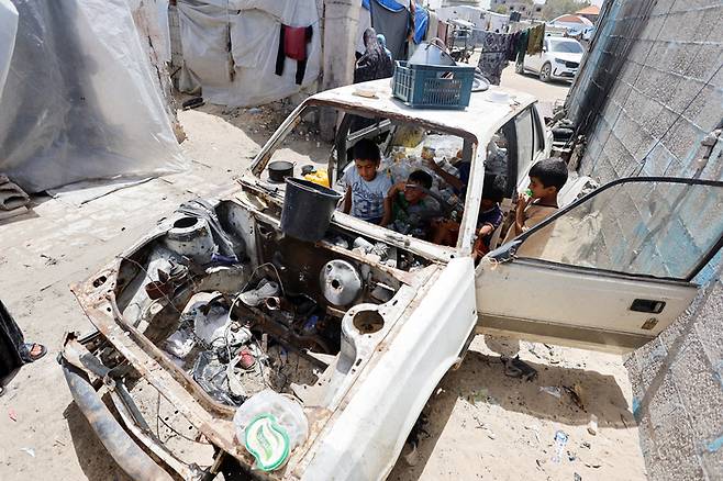 가자지구 라파에서 23일(현지시간) 팔레스타인 어린이들이 부서진 차 안에서 놀고 있다.  로이터연합뉴스