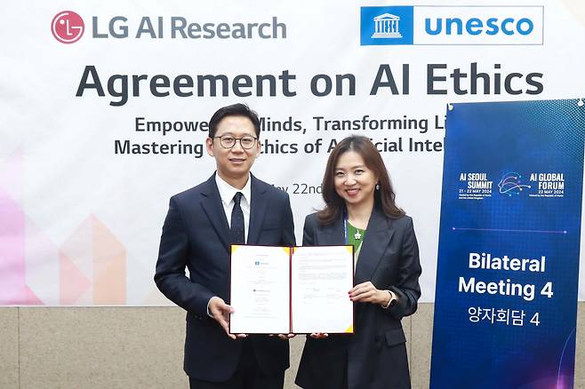 Bae Kyung-hoon (left), chief of LG AI Research, and Kim Soo-hyun, director of the UNESCO Asia and Pacific, pose for a photo after signing an agreement on AI ethics at the Korea Institute of Science and Technology in Seoul on Wednesday.