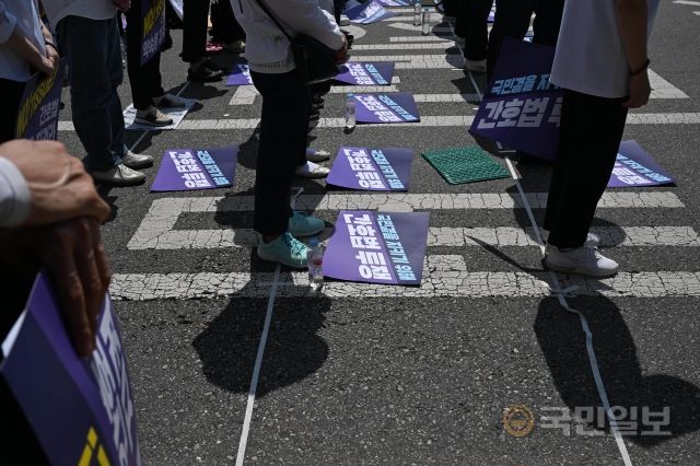 23일 서울 여의도 국회의사당역 인근에서 열린 '전국 간호사 간호법안 제정 촉구 결의대회'에서 대한간호협회 회원들이 묵념을 하고 있다.