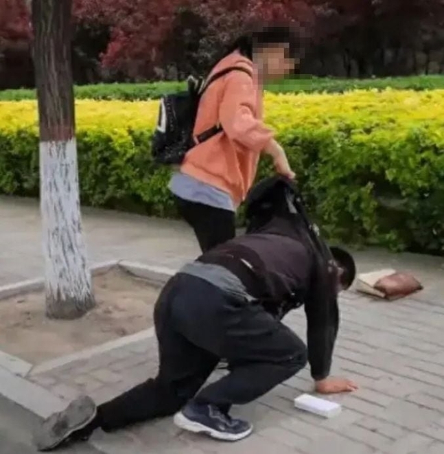 한 아버지가 10대 딸에게 무릎을 꿇고 사과하는 모습/사진=바이두