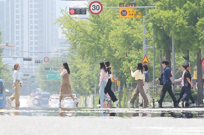초여름 날씨를 보인 22일 오후 서울 영등포구 여의도공원 인근 도로에서 지열에 의한 아지랑이가 피어오르고 있다. [연합]